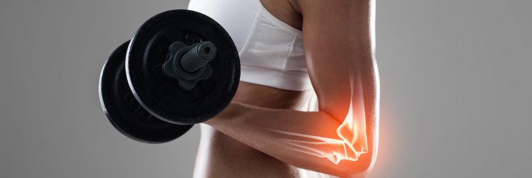 Shot of a woman holding a dumbbell with her elbow joint being highlighted